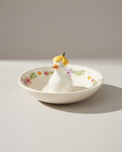 Decorative ceramic dish shaped like a duck with floral patterns on a light gray background