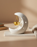 Decorative candle holder shaped like a moon with a star and gold balance scale on a beige background